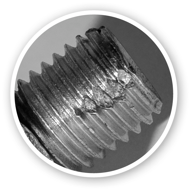 Defective metric bolt with nut closeup against a dark background