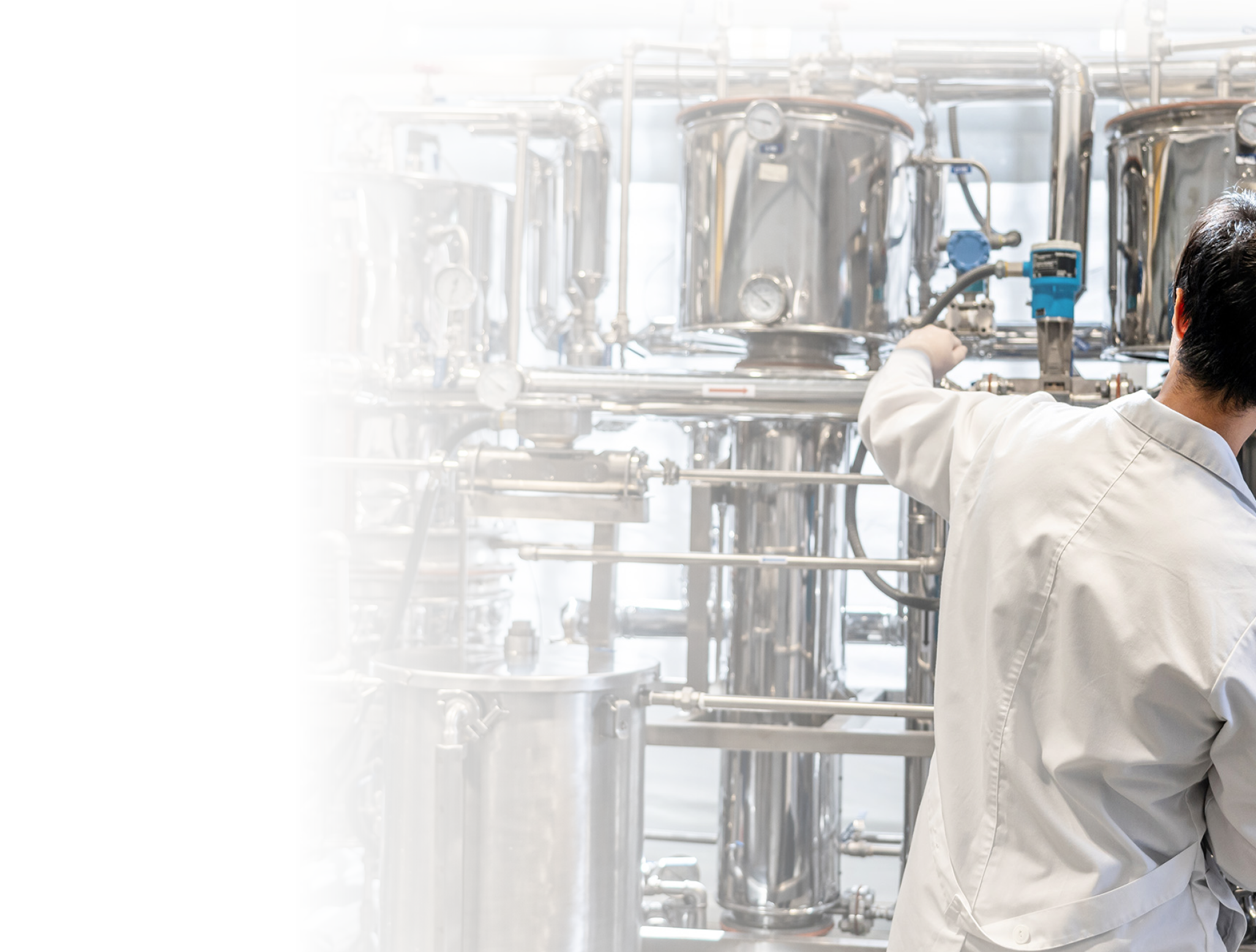 Back view of male student working at the process lab distilling liquids - Education concepts