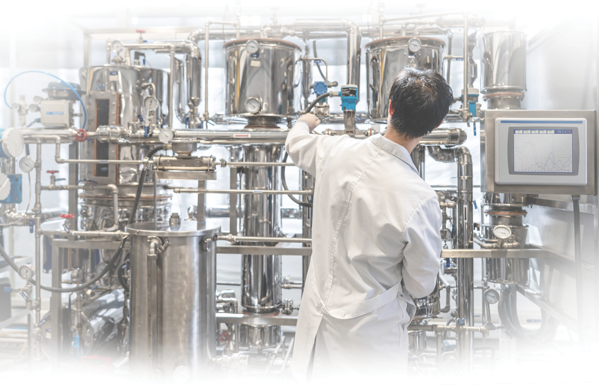 Back view of male student working at the process lab distilling liquids - Education concepts