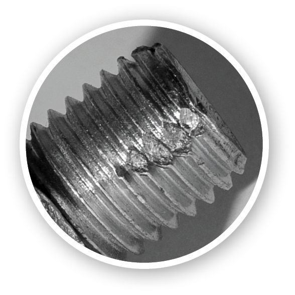 Defective metric bolt with nut closeup against a dark background