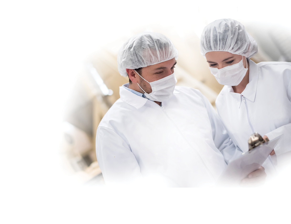 People working at a food factory doing quality control and reading documents on a clipboard